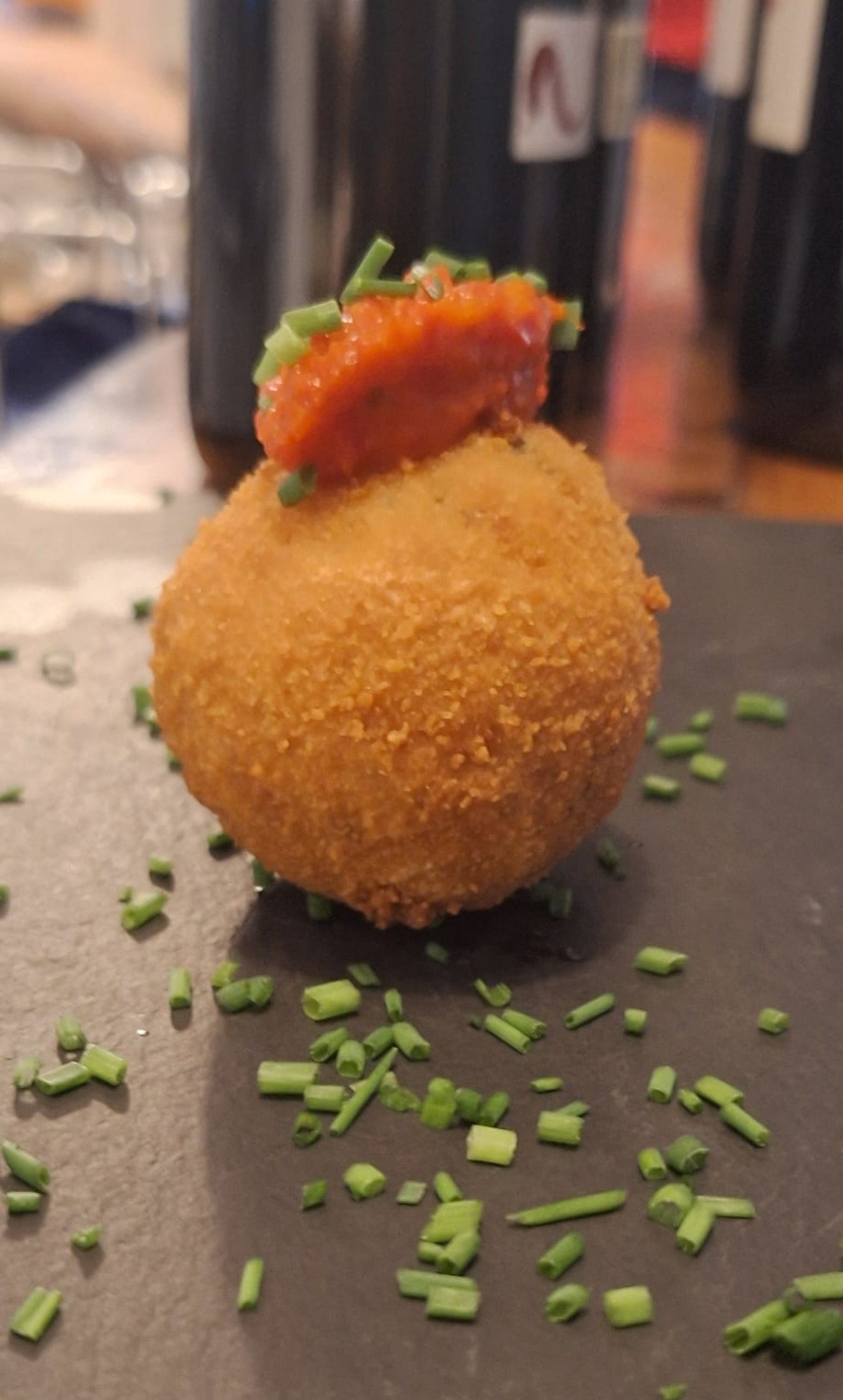 Goldbraun gebackenes Arancino mit Tomate und Schnittlauch
